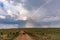 Rainbow striking on the rough road wildebeests crossing Landscape savannah grasslands at the Maasai Mara Triangle National Game Re