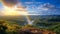 rainbow on sunset sky across a stunning vista landscape,mountains wildflowers sun flares