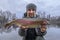 Rainbow trout fishing. Fisherman with motley salmon fish at area pond