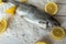 Rainbow trout over sea salt with pieces of lemon over Mediterranean wooden background