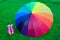 Rainbow umbrella with boots on the grass