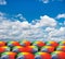 Rainbow umbrellas on cloudy sky