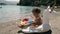 Rainbow unicorn toy and baby on the beach. Summer vacation to the sea. Greece