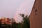Rainbow in urban colony and purple sky.