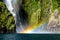 Rainbow on waterfall Milford Sound in New Zealand