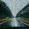 Raindrops flowing outside front windshield, close up rainy day view