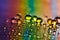 Raindrops on a window on a colorful rainbow background