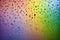 Raindrops on a window on a colorful rainbow background