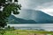 Raining over the hills and mountains and a lake.