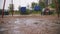 raining on playground. close-up. large raindrops fall into puddles, with splashes and bubbles, in the yard, during heavy