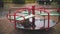 raining on playground. close-up. Wet, empty merry go round carousel , in the yard, during heavy rain.