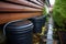 rainwater collection barrels under a house gutter