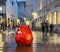 Rainy Autumn leaves on  street wet pavement city evening blurred light red candle on wooden table top people walk medieval houses