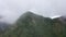 The rainy clouds covered the top of green forest mountain. Rain clouds in a tropical climate.
