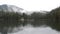 Rainy foggy day on the mountain lake Synevyr on which floats a raft with tourists