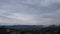 Rainy gray spring clouds over small town in mountains, timelapse