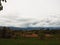 Rainy weather and blue thunderstorm in the sky overlooking the corn field and dairy cows grazing