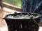 Rainy weather on the terrace in summer. The rain falls into the bucket and creates splashes.