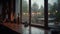 a rainy window with a view of a street and a building in the distance with a candle and a teapot on the window sill