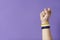 Raised fist of a person wearing a non binary flag bracelet. Gender diversity