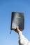 Raised hand holding the Holy Bible. Background with blue sky on a beautiful winter morning.