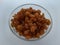 Raisins in a bowl on a plain white background.