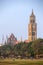 Rajabai clock tower in gothic style and green cricket field in Mumbai, India