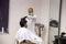 Rajasthan, india, April 24th 2020: A professional hairdresser wearing mask and gloves cutting hair to a client, Salon and