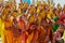 Rajasthani women wearing yellow and red sarees holding coconuts and pots take part in a religious procession in Bikaner, India.