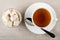 Rakhat-lukum with cherry in bowl, cup with tea, spoon in saucer on table. Top view