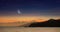 Ramadan background with crescent, stars in glowing sky above mountains and sea