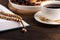 Ramadan, closeup cup of tea, plate of dried fruit, wooden rosary, Koran on brown wooden background, iftar