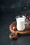 Ramadan Kareem food and drinks. Plate of dates, glass of milk and date palm branch on black background. Righteous Muslim Lifestyle