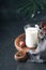 Ramadan Kareem food and drinks. Plate of dates, glass of milk and date palm branch on black background. Righteous Muslim Lifestyle