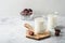 Ramadan Kareem food and drinks. Plate of dates, glass of milk and date palm branch on light grey background. Righteous Muslim