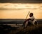 A rambler resting on a hill at sunset with his dog