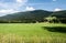 Ramzovske sedlo in Jeseniky mountains in Czech republic with mountain meadows, houses, hills and blue sky with clouds