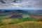 Rana Hill, in Ceske Stredohori mountain, Czech Republic. Hill with clouds. Beautiful morning landscape. Village below the hill. La