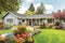 ranch house exterior with lush lawn, flowerbeds and welcoming front porch