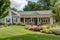 ranch house exterior with lush lawn, flowerbeds and welcoming front porch