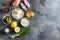 Ranch sauce in a white porcelain bowl with ingredients eggs capers,vegetables, herbs and spices on an grey stone textured table