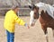 Rancher feeding her horse.