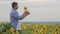 Rancher man in sunflower field. Satisfied farmer in a sunflowers field looking at sunflower seeds.