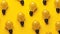 Random pattern of light bulbs on yellow background