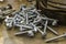 Random pile of hexagonal threaded steel bolts or screws.