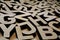 Random wooden letters lying on wooden background.