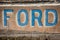 RANDSBURG, CALIFORNIA: An old rusted Ford sign in blue and brown, close up view