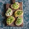 Range of healthy sandwiches with avocado, hummus, ricotta, cucumber, sunflower sprouts, micro greens and flax seeds. On a wooden c