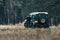 Ranger with jeep in field near forest. National Park Hoge Veluwe.