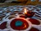 Rangoli with oil lamps rich colors drawn on the auspicious occasion of indian festivals. Diya oil lamps lit on colorful rangoli